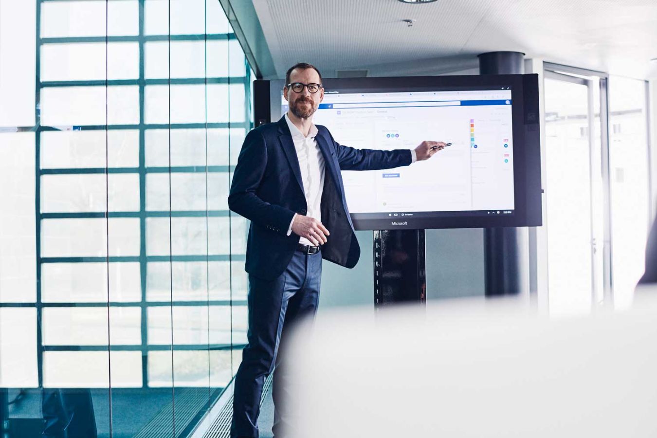 Man presenting and pointing at a TV screen