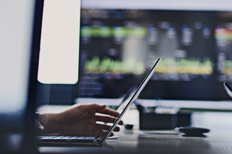 close up of people on laptops with a screen in the background